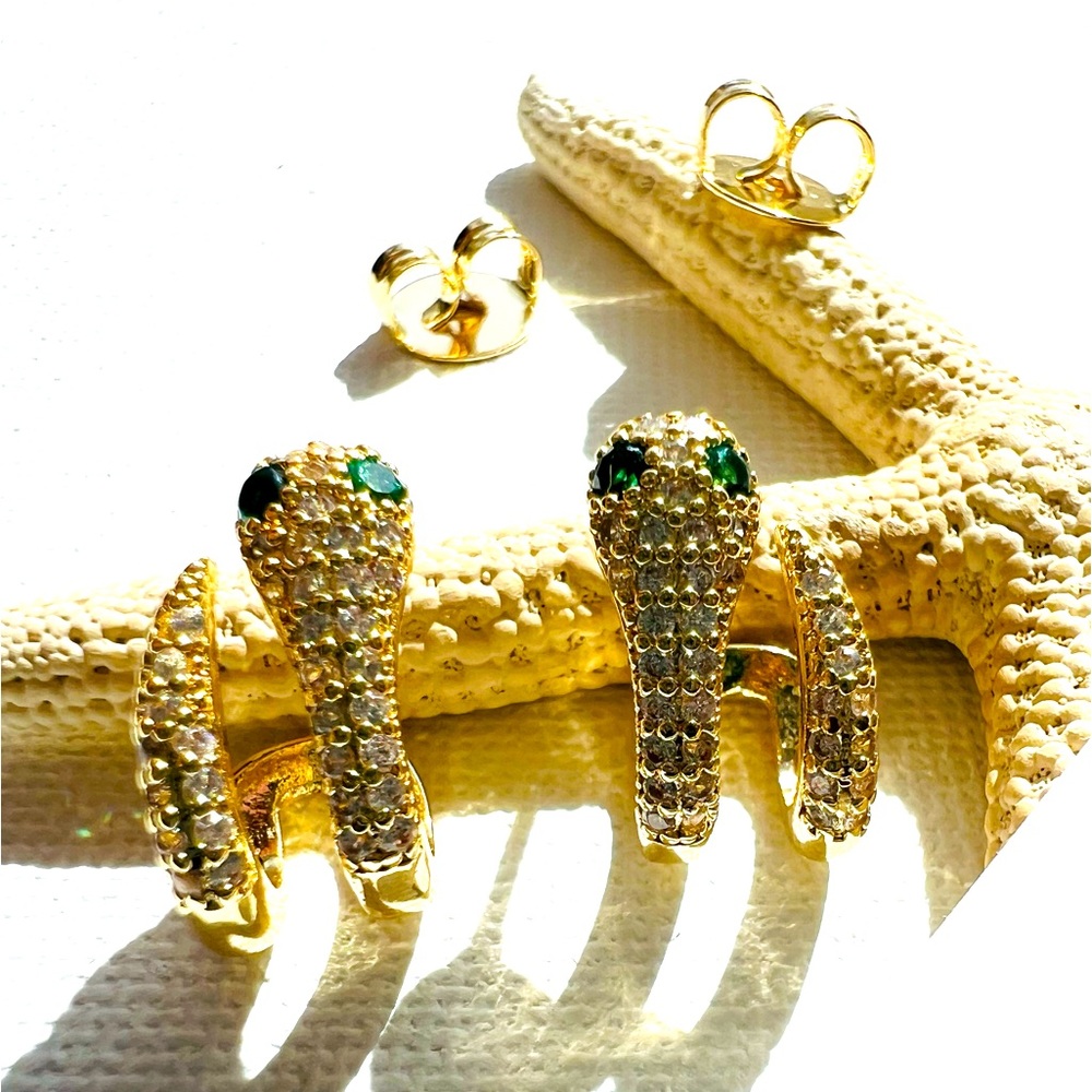 Aretes de serpiente abrillantada con piedras verdes brillantes en los ojos.